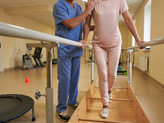 Patient walking between parallel bars in a rehabilitation clinic
