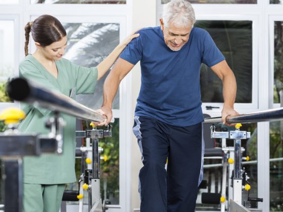 Physiotherapist motivating a senior patient to walk