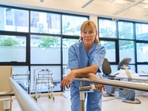 A,Senior,Nurse,In,A,Rehabilitation,Facility,,Wearing,Blue,Scrubs, Nurse working in a rehabilitation facility